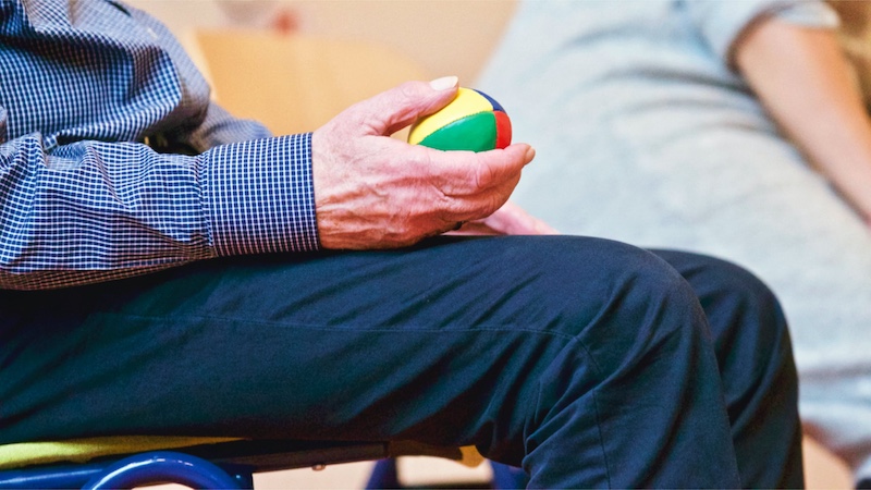 Man squeezing an occupational therapy ball